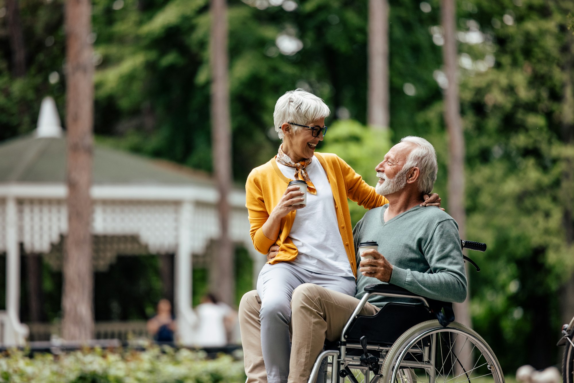 Mature disabled man, embracing his wife.